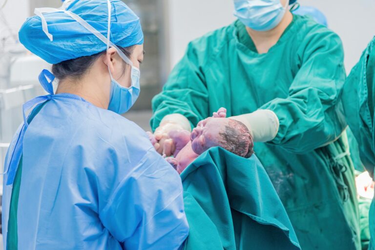Medical professionals holding a newborn baby in a hospital setting, highlighting care.
